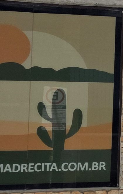 Painel ilustrado ao lado da casa: sol laranja, morros verdes e um cacto, com o endereço madrecita.com.br.